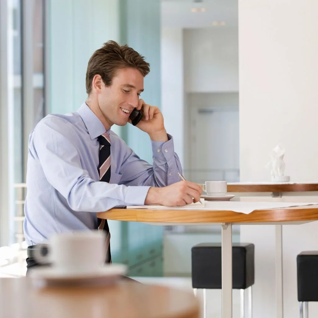 A professional working through decisions by phone and laptop
