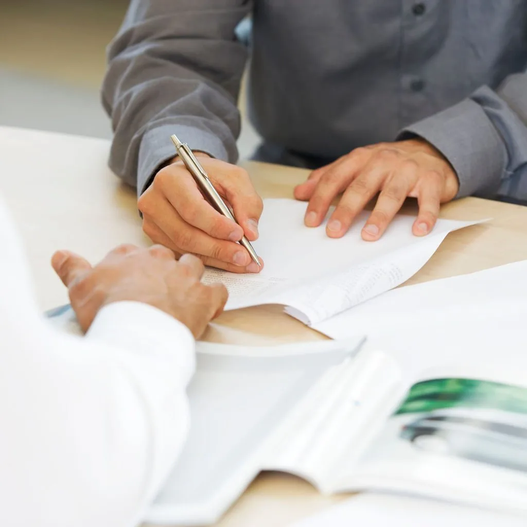 Reviewing and signing planning documents at a desk