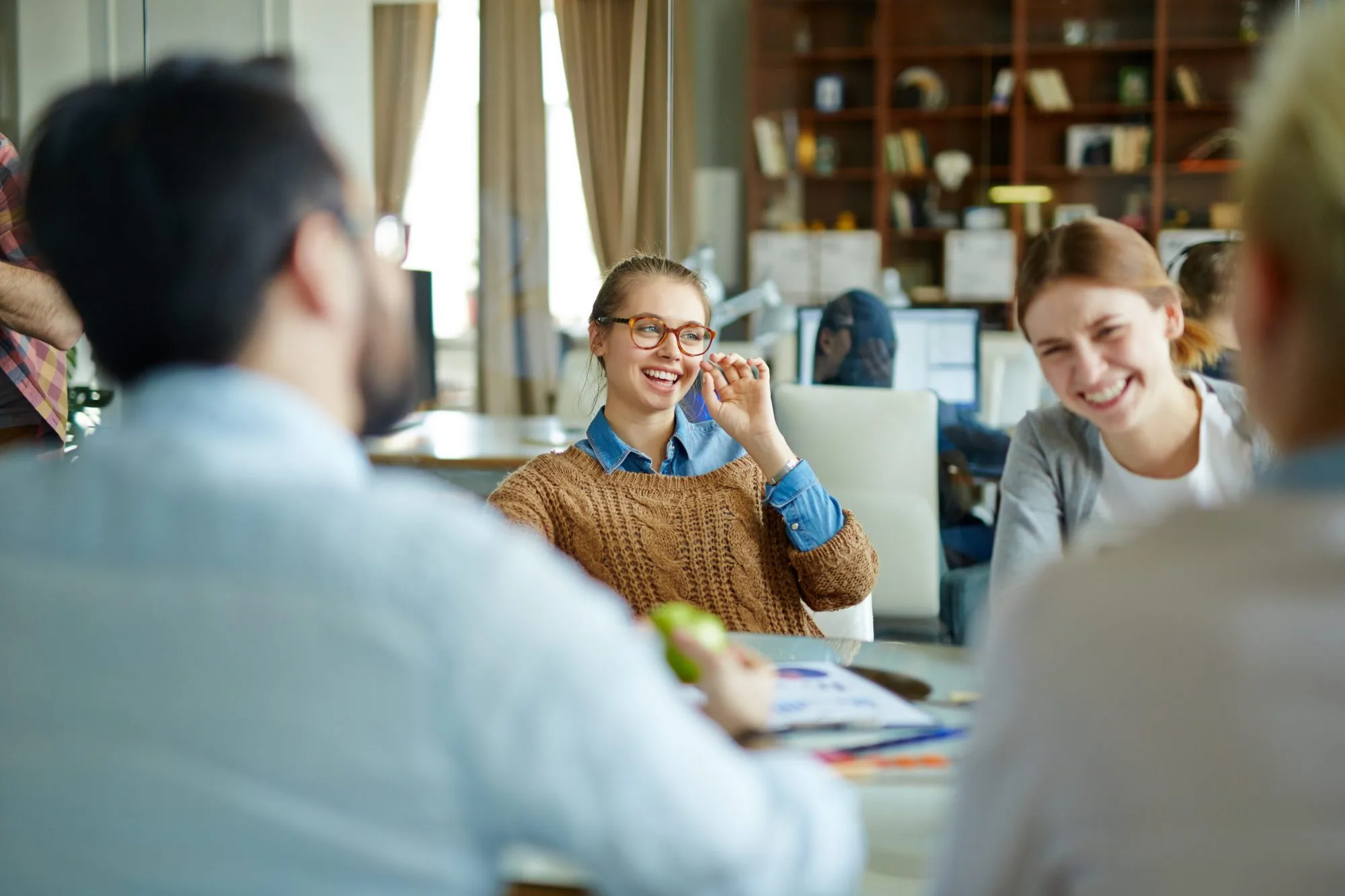 A team talking through ideas around a table in a bright office